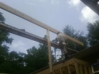 Carpenter setting a ridge beam over a new addition frame — Ice Dam Removal by Roofing Brothers in Cary